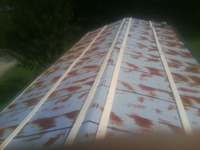 Rusted metal roof panels with new wood purlins before replacement — Storm Damage Roof Repair in Lissie by Roofing Brothers