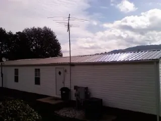 New metal roof on a single wide mobile home with a TV antenna in Lissie