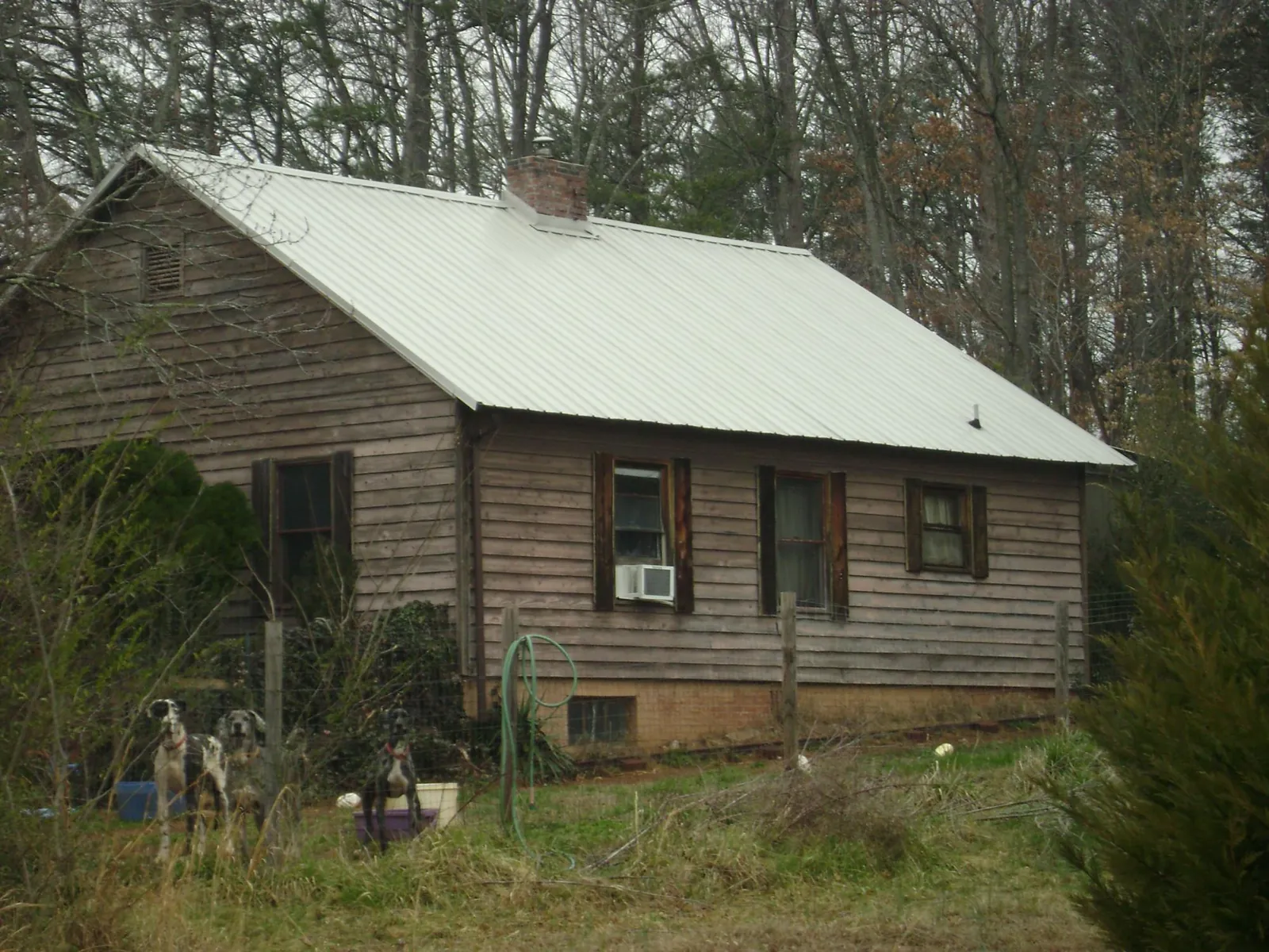 White metal roof on an old wood sided farmhouse, from a Metal Roof Installation job in Lissie